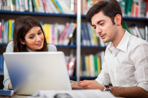 Dwóch Studentów Korzystających Z Laptopa W Bibliotece