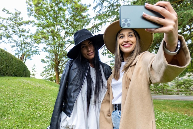 Dwóch stylowych przyjaciół robi sobie selfie w parku