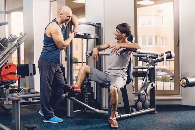 Dwóch szczęśliwych mężczyzn omawia dzisiejszy trening fitness.