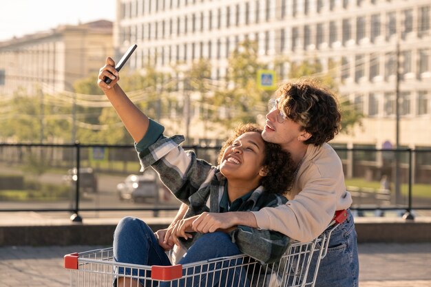 Dwóch szczęśliwych milenialsów robi selfie w środowisku miejskim