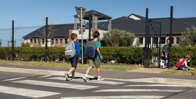 Dwóch uczniów przechodzących przez jezdnię na przejściu dla pieszych