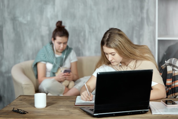 Dwóch uczniów wspólnie przygotowuje się do egzaminu, korzystając z laptopa i telefonu.