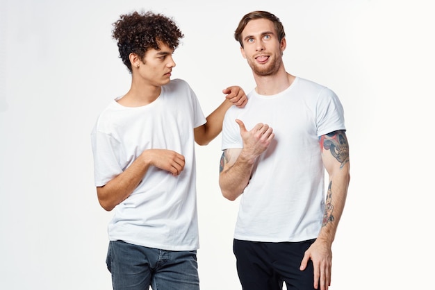 Dwóch wesołych przyjaciół w białych koszulkach ogarnia emocje