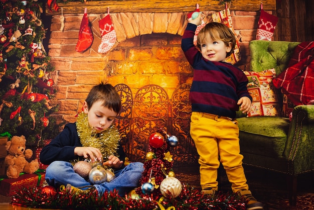 Dwoje dzieci bawiących się ozdób choinkowych. Wesołych Świąt
