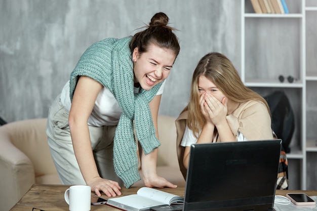 Dwoje Studentów Patrzy Na Laptopa, śmieje Się I Bawi, Plotkując W Internecie