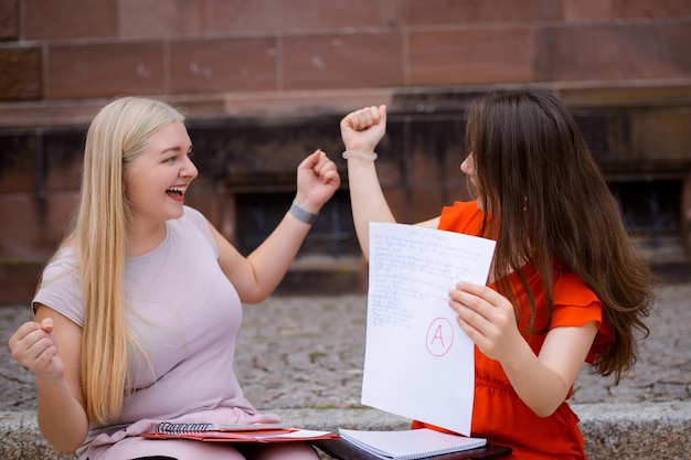 Zdjęcie dwoje szczęśliwych studentów ze zdanym egzaminem końcowym