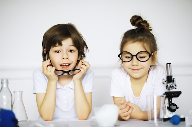 Zdjęcie dwoje uroczych dzieci na lekcji chemii robiące eksperymenty na białym tle