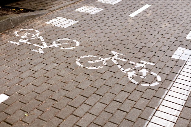 Dwukierunkowa ścieżka rowerowa, oznakowanie ścieżki rowerowej na chodniku, malowany na biało znak rowerowy na drodze na ulicy. Symbol drogi rowerowej. Jeździć na rowerze, na rowerze, na rowerze, na kółkach i koncepcji zdrowego stylu życia