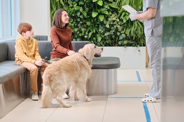 Dwuosobowa rodzina z labradorem odwiedza weterynarza w klinice weterynaryjnej