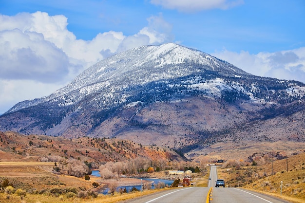 Dwupasmowa droga utwardzona w górach prowadząca do ogromnej, zaśnieżonej góry w zachodniej Ameryce