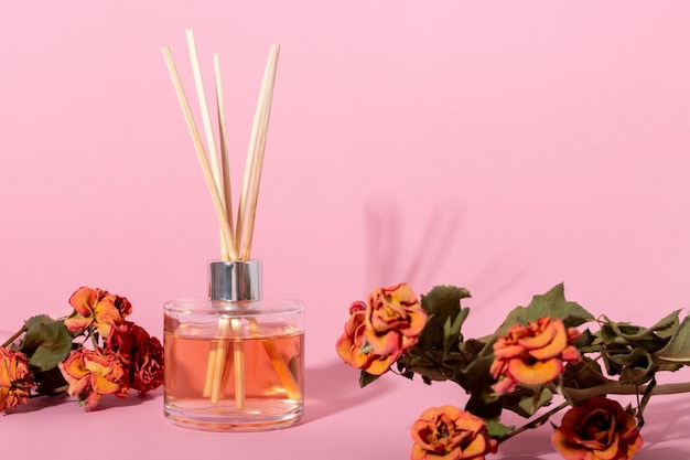 Zdjęcie dyfuzor trzcinowy z kwiatami kadzidełka do domu o kwiatowym zapachu z twardymi cieniami koncepcja ekologicznego zapachu do domu