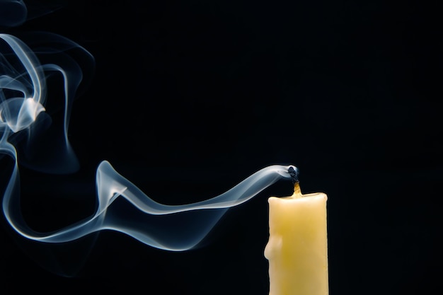 Zdjęcie dym z zgaszonej świecy na ciemnym tle koncepcja duchowości i końca życia