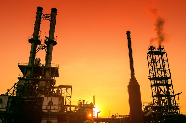 Dymne Stosy Przemysłu Petrochemicznego Na Zachód Słońca Pomarańczowego Nieba, Zakładu Przemysłowego Ropy I Gazu