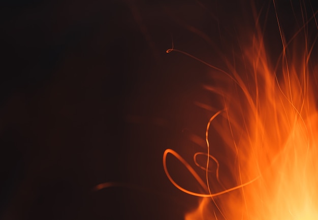 Dynamiczne linie ślady czerwonych, gorących iskier z ogniska w nocy.