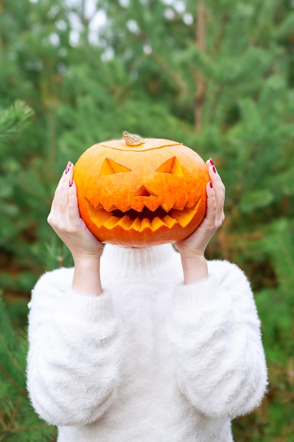 Dynia jackolantern w rękach dziewczyny zbliżenie Halloween party