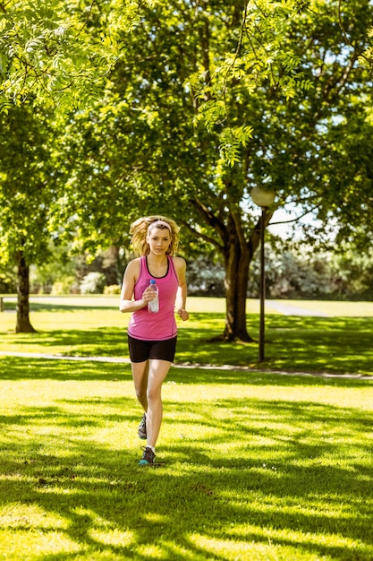 Zdjęcie dysponowana blondynka jogging w parku