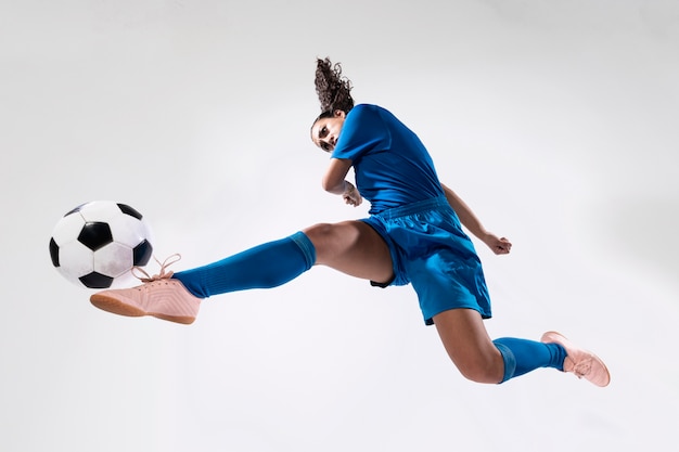 Zdjęcie dysponowana dorosła kobieta bawić się piłkę nożną