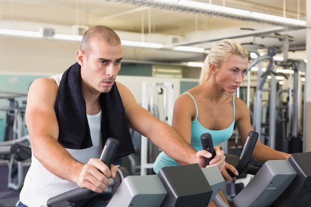 Dysponowana para pracuje na ćwiczenie rowerach przy gym