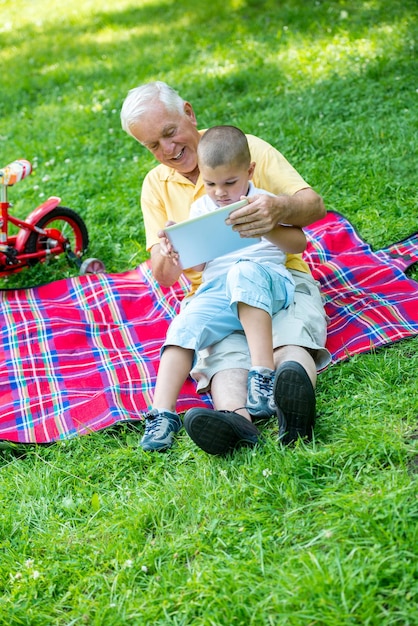 dziadek i dziecko za pomocą komputera typu tablet w parku