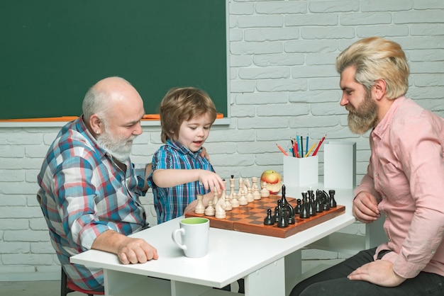 Dziadek i syn grają w szachy w różnym wieku, gotowi uczyć się szczęśliwej rodziny w klasie
