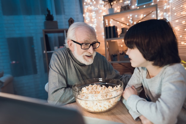 Zdjęcie dziadek i wnuczek, oglądając film na laptopie