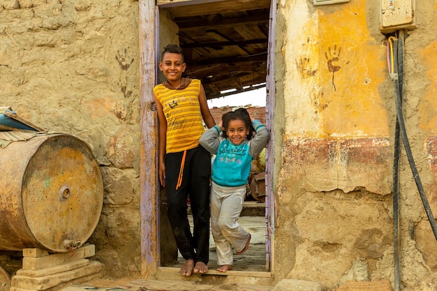 Dzieci Afryki. Wesoły brat i siostra stoją w drzwiach swojego domu. Egipt