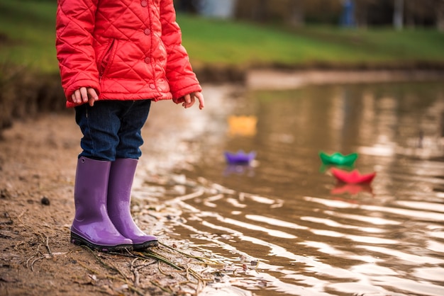 Dzieci Bawią Się łódkami Na Brzegu Rzeki. Słoneczna Jesień. żółty Park. Niebieska Rzeka O Zachodzie Słońca