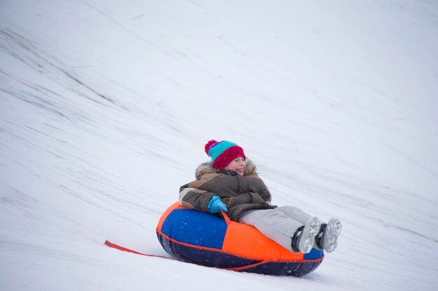 Dzieci bawią się na świeżym powietrzu na śniegu Dzieci na sankach w Alpach w