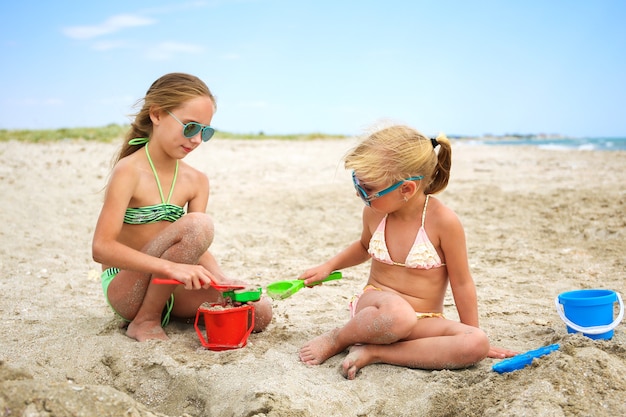 Dzieci bawią się piaskiem na plaży.