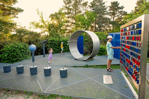 Dzieci bawią się teleskopami i innymi przedmiotami w parku obserwatorium w planetarium