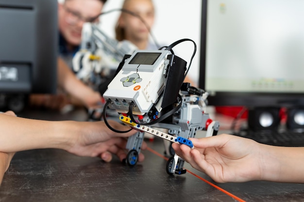 Dzieci bawią się z psem robotem na lekcji robotyki