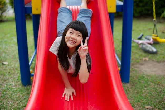 Dzieci bawiące się na placu zabaw happy girl odtwarzanie slajdów