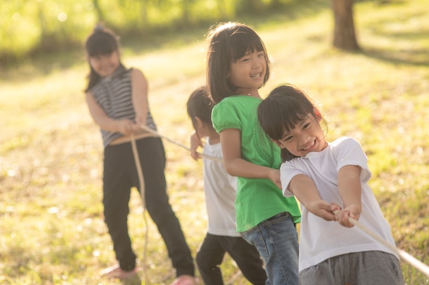 Dzieci bawiące się w przeciąganie liny w parku na sunsut