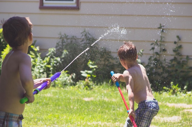 Dzieci bawiące się wodą na podwórku