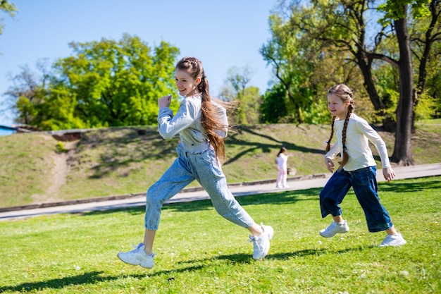 Zdjęcie dzieci biegają po zielonym trawniku w słoneczny dzień