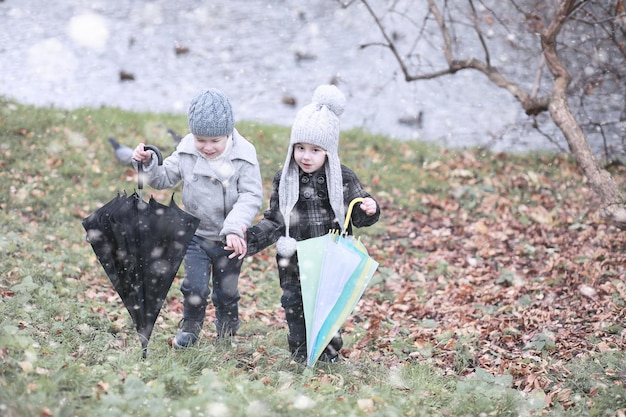 Dzieci chodzą po parku pierwszy śnieg