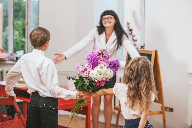 Dzieci Dają Kwiaty Jako Nauczycielka W Dzień Nauczyciela