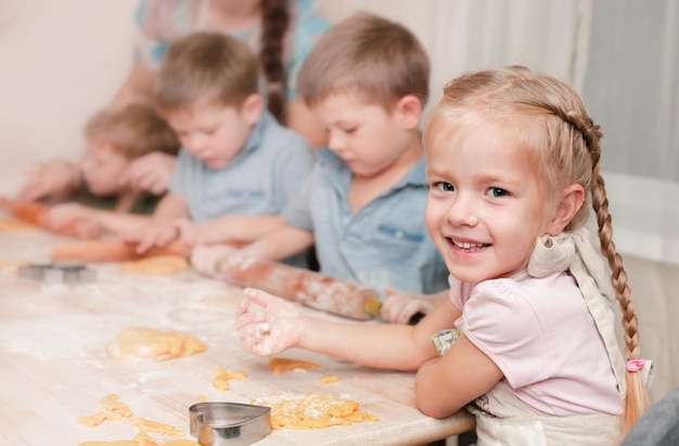 Dzieci gotują ciasteczka z całą rodziną Dziewczyna się uśmiecha