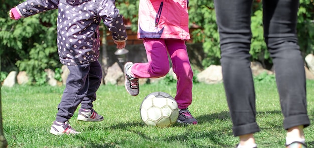 Dzieci Grają W Piłkę Nożną Na Trawie, Trzymają Nogę Na Piłce. Pojęcie Gry Zespołowej.