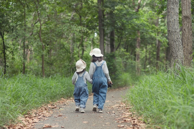 Dzieci jadą na rodzinny kemping w lesie. Spacer szlakiem turystycznym. Droga kempingowa. Koncepcja wakacji rodzinnych podróży.