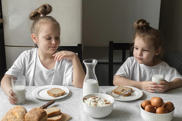 Dzieci jedzą śniadanie w domu w kuchni ze zdrową i zdrową żywnością
