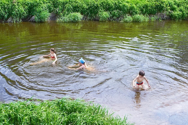 Dzieci kąpią się w rzece w letni dzień