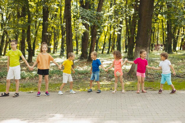 Zdjęcie dzieci na obozie letnim robią falę trzymając się za ręce