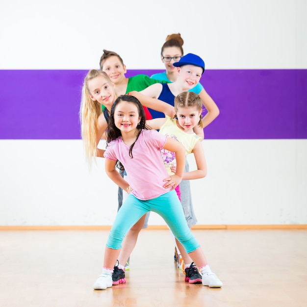 Dzieci na zajęciach zumby tańczą w nowoczesnej choreografii grupowej