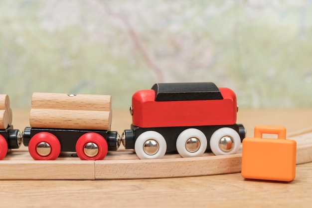 Dzieci pociąg i miniaturowa walizka na stole na tle mapy jako koncepcja podróży pociągiem
