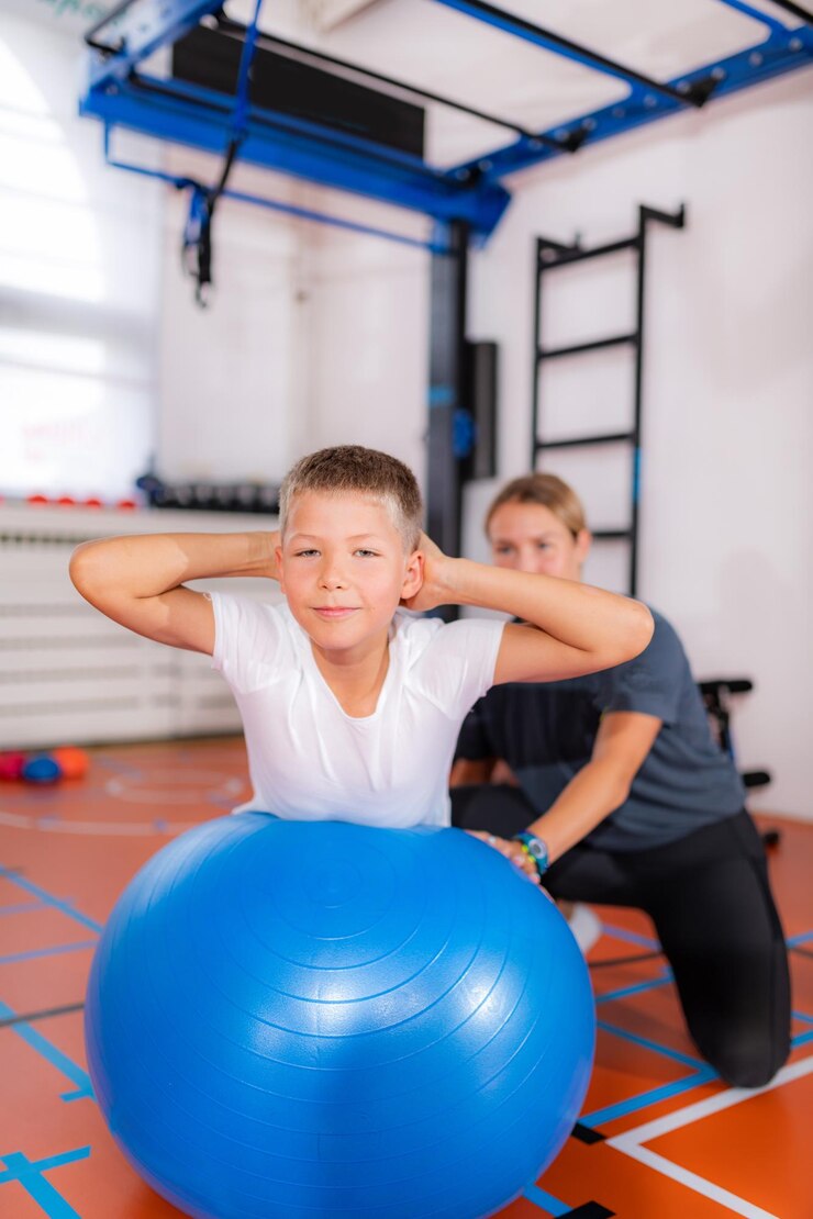 Dzieci podczas zajęć ruchowych ćwiczących z piłkami fitness