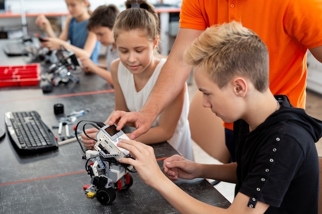 Dzieci pracują z nauczycielem nad projektem edukacji robotów