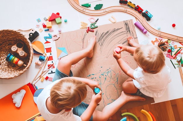 Dzieci Rysują I Wykonują Rękodzieło Dzieci Z Zabawkami Edukacyjnymi I Przyborami Szkolnymi Dla Kreatywności