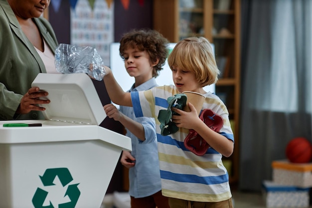 Dzieci sortujące plastik i papier na zajęciach z recyklingu w przedszkolu