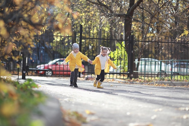 Dzieci spacerują po jesiennym parku jesienią